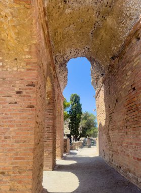 Taormina, Sicilya, İtalya - 5 Temmuz 2024: Antik Yunan tiyatrosunun veya Teatro Antico 'nun SE kalıntıları. Kavisli tavan ve sonunda ağaçlar.