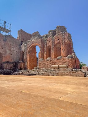 Taormina, Sicilya, İtalya - 5 Temmuz 2024: Antik Yunan tiyatrosu veya Teatro antico sahne arkasında SW 'nin kalıntıları. 