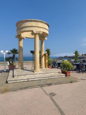 Taormina, Sicilya, İtalya - 5 Temmuz 2024: Olimpiyat Tapınağı Naxos rıhtımın dibinde, arkada mavi gökyüzünün altında deniz var