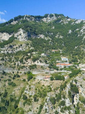 San Michele, Salerno, İtalya - 6 Temmuz 2024: Birkaç otel binasıyla dağ sırasına bakıyorum. Teras tarımı en üstte.