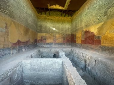 Pompeii, Campania, İtalya - 6 Temmuz 2024: Antik Roma şehri kalıntıları. Casa del Menandro. Boyalı duvarları ve çatısı olan büyük bir banyo tesisi.