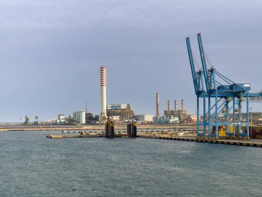 Civitavecchia, İtalya - 7 Temmuz 2024: Liman. Torrevaldaliga Nord kömür yakıtlı elektrik santrali konteyner terminalinin arkasında uzun bacaları var.