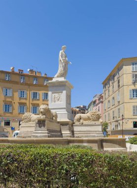 Ajaccio, Korsika, Fransa 8 Temmuz 2024: Fontaine des quatre lions, dört aslan çeşmesi, üstünde Roma Konsolosu gibi giyinmiş Napolyon heykeli. Önde yeşil bitkiler var. Arkadaki binalar.