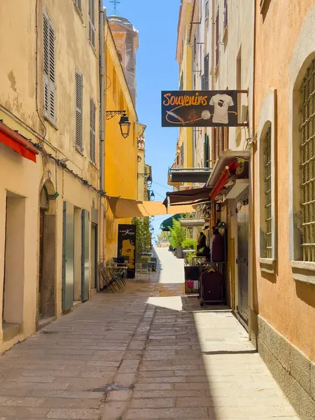 Ajaccio, Korsika, Fransa 8 Temmuz 2024: Bonaparte Müzesi yakınlarındaki Saint Charles sokağından deniz kenarındaki SW 'ye bakıyorum. Hediyelik eşya dükkânı ve dar bir sokakta sarı cepheli bistrolar.