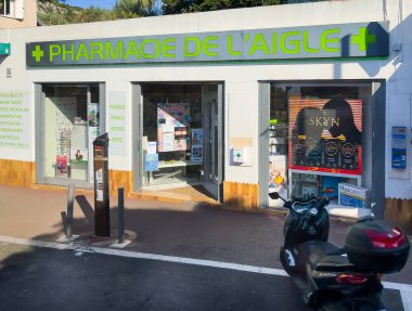 Eze, Fransa - 9 Temmuz 2024: M6007 yolu boyunca Pharmacie de l 'Aigle, önde motosikletli ön cephe, Poducts kartlarını göster