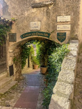 Eze, Fransa - 9 Temmuz 2024: Chateau de la Chevre d 'Or otelin girişi kadim bir kemerli sarı duvardır. Bol yeşillik var. Altın keçi şatosu.