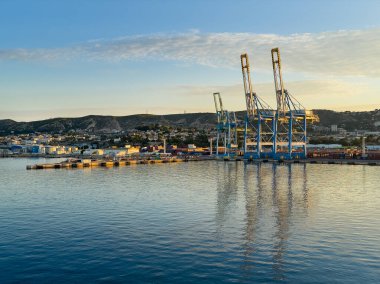 Marsilya, Fransa - 10 Temmuz 2024: Limandaki konteyner terminali ve vinçleri, geniş manzara. Mediaco Vrac tankları solda görünüyor.