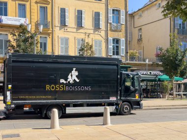 Aix-en-Provence, Fransa - 10 Temmuz 2024: Rossi Boissons, içkiler, arkada bir optik mağazası olan dağıtım kamyonu. Sokak sahnesi