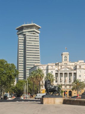 Barcelona, İspanya - 11 Temmuz 2024: Kule, Torre Drassaness, Komandancia Donanma binasının arkasındaki ofis Placa Portal de la Pau Meydanı 'ndan görüldü. Columbus anıtının siyah aslan heykeli