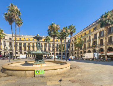Barselona, İspanya - 11 Temmuz 2024: Barri Gotic, Placa Reial Meydanı. Fuente de las Tres Gracias, Üç Zarafet Çeşmesi, meydanın ortasında. Etraftaki tarihi binalar. Teslimat kamyonları