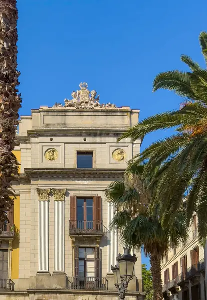 Barselona, İspanya - 11 Temmuz 2024: Barri Gotic, Placa Reial Meydanı. Carer de Colon sokağının köşesindeki tarihi kraliyet sarayında heykel ve arma bulunmaktadır.