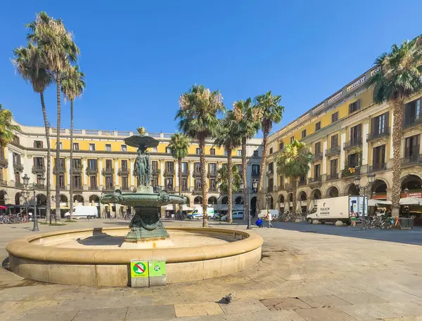 Barselona, İspanya - 11 Temmuz 2024: Barri Gotic, Placa Reial Meydanı. Fuente de las Tres Gracias, Üç Zarafet Çeşmesi, meydanın ortasında. Etraftaki tarihi binalar. Teslimat kamyonları