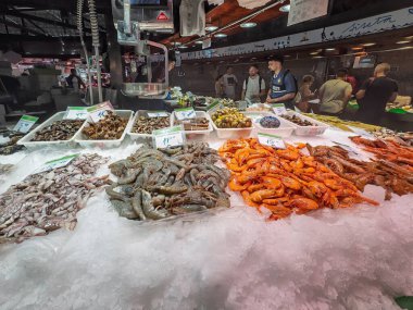 Barselona, İspanya - 11 Temmuz 2024: Mercat de la Boqueria, pazarı kapsıyordu. Kabuklu deniz ürünleri, karides, kabuklular ve bekleyen tüccarlarla birlikte sergilenecek.