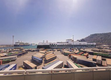 Barcelona, İspanya - 11 Temmuz 2024: Grimaldi Hybrid RoRo feribot iskeledeki konteynır hatlarıyla birlikte limanda. Ufukta seyir gemileri