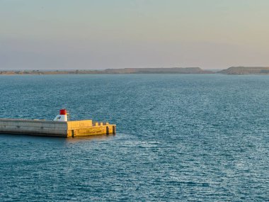 Barselona, İspanya - 11 Temmuz 2024: Koruma bariyerinin sonu, limanın güney kısmında ışık feneri bulunan iskele