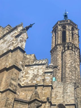 Barcelona, İspanya - 11 Temmuz 2024: Barri Gotic, On Placa de Sant Iu, Carrer dels Comptes tarafından görülen Katedral 'in yan kulesi. Duvarın tepesindeki heykeller