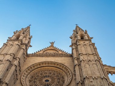 Palma de Mallorca, İspanya - 12 Temmuz 2024: Katedral, Santa Maria de Mallorca. Giriş cephesinin mimarisi dev Gotik güllere, kulelere ve en üstteki Bakire Meryem heykeline bakıyor.