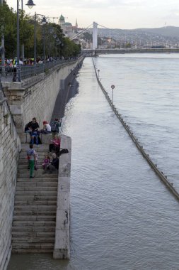 Budapeşte, Macaristan - 18 Eylül 2024: İnsanlar nehir kıyısında yürürken Tuna Nehri Budapeşte 'yi sular altında bırakıyor.