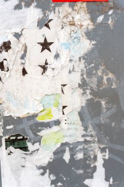 Boyanın soyulması şehir tarihinin katmanlarını gözler önüne seriyor. Yıldızlar ve şehir sokaklarındaki yıpranmış bir duvarda kısmen gizlenmiş bir tasarım..
