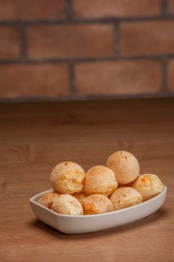 Cheese breads in a white serving dishe on wooden  table.