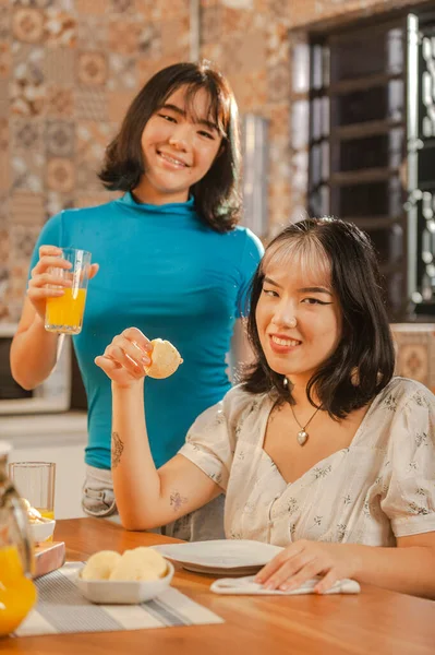 Young asian lady holding a cheese bread on the breakfast.
