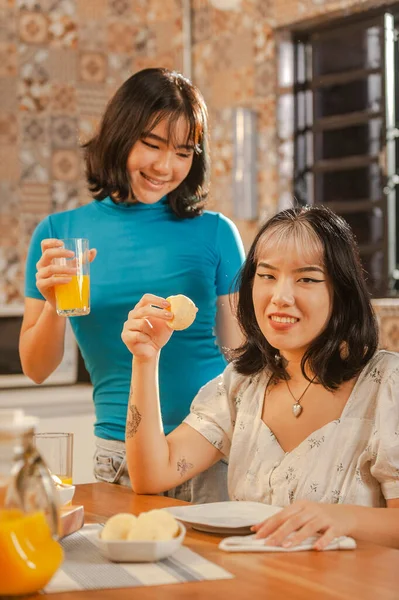 Young asian lady holding a cheese bread on the breakfast.