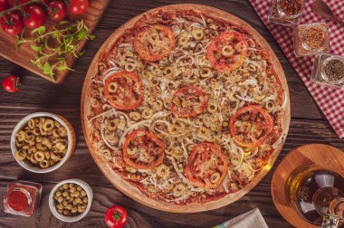 Brazilian pizza with mozzarella, tuna, pea, onion, olive and tomato (Pizza especial de atum) - Top view.