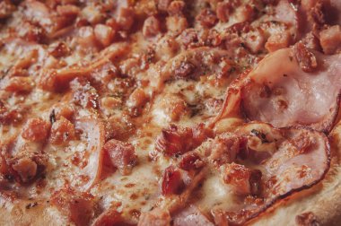 Brazilian pizza with tomato sause, mozzarella, pork loin, bacon and oregano (Pizza de lombinho e bacon) - Closeup.