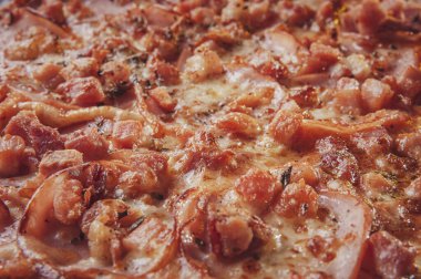 Brazilian pizza with tomato sause, mozzarella, pork loin, bacon and oregano (Pizza de lombinho e bacon) - Closeup.