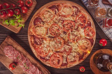 Brazilian pizza with mozzarella, salami, tomato and parmesan cheese(Pizza de salame com parmesao) - Top view.