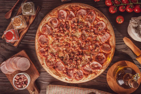 Brazilian pizza with tomato sause, mozzarella, pork loin, bacon and oregano (Pizza de lombinho e bacon) - Top view.