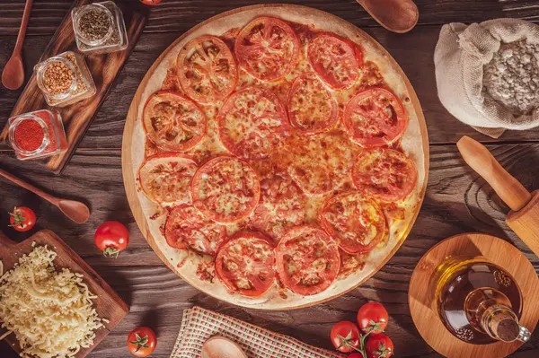 Brazilian pizza with mozzarella, tomato and oregano (Pizza de mussarela) - Top view.