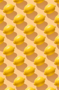Sarı pastel üzerine limon uzun gölgeli yumuşak renk. En az sağlıklı organik gıda konsepti. Turunçgil meyvesi. Düz yatış, üst görünüm