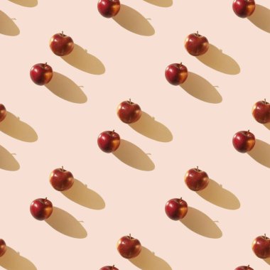 Açık bej renkli, uzun gölgeli iki kırmızı elma. Kusursuz desen