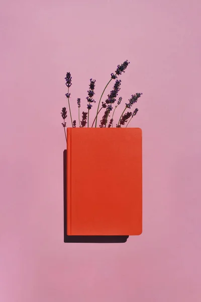 Orange Book Notebook Lavender Flowers Pink Background Long Shadows Knowledge — Φωτογραφία Αρχείου