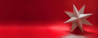Kırmızı arka planda gölgeli gümüş parıltılı yıldız süslemesi. Kış tatili kartpostal modeli. Yeni yıl ya da en az Noel konsepti. Pankart. Uzayı kopyala Metin için boşluk