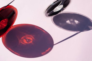 Farklı boyutlarda, soluk pembe arka planda derin gölgeler olan eski manyetik kasetler. Retro ya da klasik estetik. Nostalji kavramı