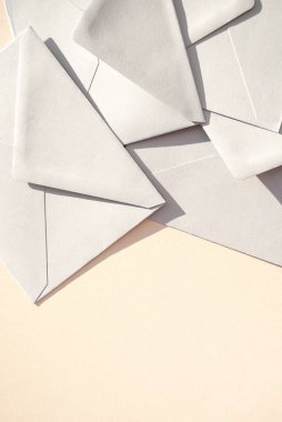 Bej arka planda gri kağıt zarflar. İş ya da ofis kavramı. Uzayı kopyala Mesaj için yer var. Düz yatıyordu. Üst görünüm