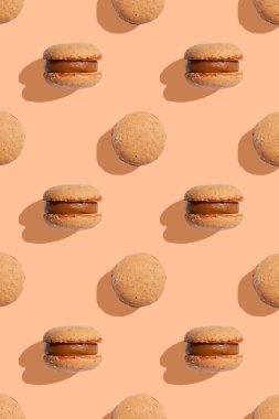 Şeftali tüylü arka planda bej renkli kurabiyeler. Makarna kurabiyeleri. Tek renkli resim