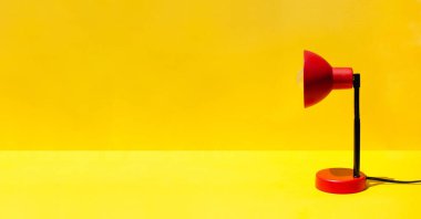 Odada fotokopi alanı olan kırmızı lamba var. Parlak sarı arka planda kırmızı bir lamba. Asgari ofis ya da okul ekipmanı. Okula ve ofis konseptine geri dönüyorum. Minimum şablon konsepti. Pankart
