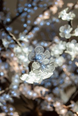 Şeffaf beyaz çiçekleri ve serin mavi ışığı olan bahçe LED ağacı. Sokak LED ağacı. İç tasarım ayrıntıları