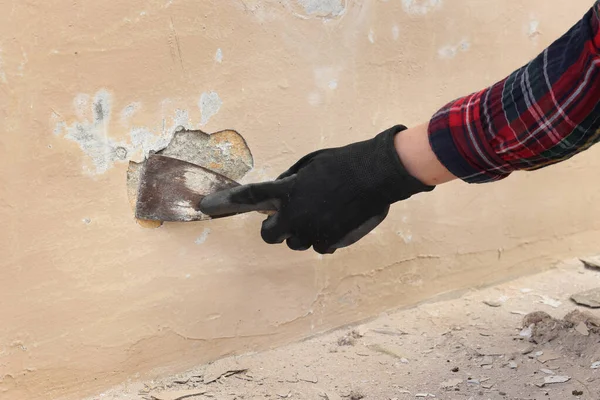 損傷したモルタル除去 手袋とスクレーパーツールで手の閉鎖を使用して古い壁を固定労働者 — ストック写真