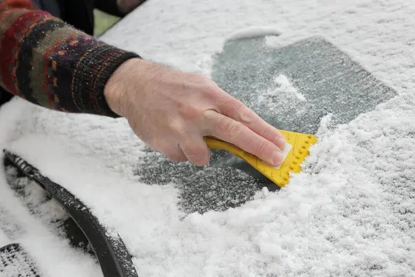 Winterszene Menschliche Hand Kratzt Eis Von Der Windschutzscheibe Des Autos lizenzfreie Stockbilder