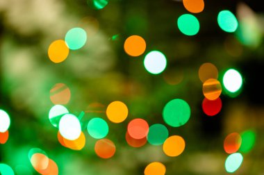 Odaklanmamış renkli ışıklarla dolu bir arka plan. Bulanık ışık izleri ve noel ağacı lekeleri.