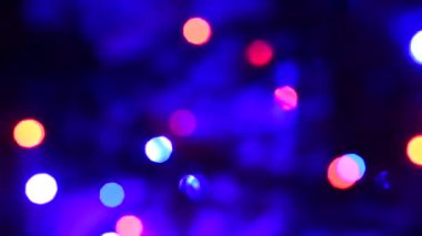 Arka plan odaklanmamış renkli ışıklarla dolu. Bulanık ışıklar ve noel ağacı lekeleri.