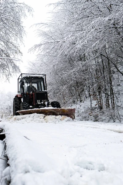 A tractor shoveling snow from a mountain road in the Carpathians, Poland.