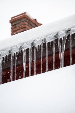 Tehlikeli keskin sarkıtlar ve çatıdan sarkan kar. Tehlikeli kış durumu.