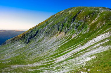 Yaz günü dağ manzarası. Yeşil kayalık dağlar ve mavi bir gökyüzü. Setea Mare Dağı, Parang Dağları, Romanya.