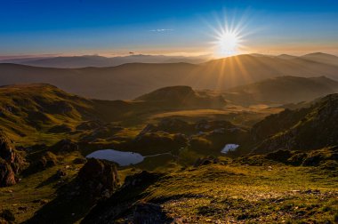 Doğan güneşli dağ manzarası. Fotokopi alanı olan karanlık bir arkaplan. Parang Dağları, Romanya.