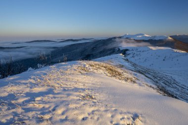 Güzel kış dağ manzarası. Polonya 'nın Bieszczady Ulusal Parkı' ndaki Smerek Dağı 'ndan görülen kasvetli gün batımı.